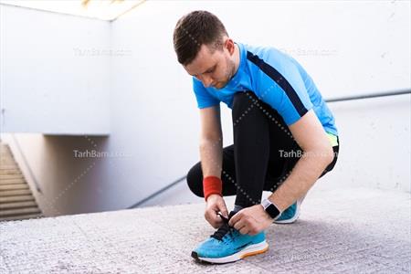 تصویر با کیفیت مرد در حال بستن کفش